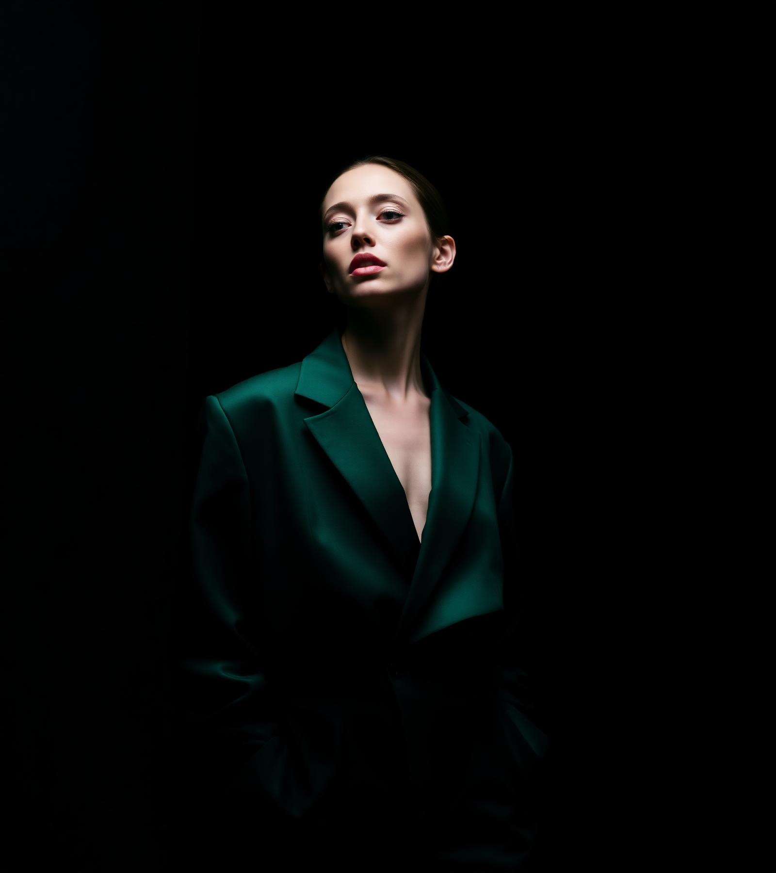 Editorial portrait of a model in an emerald blazer